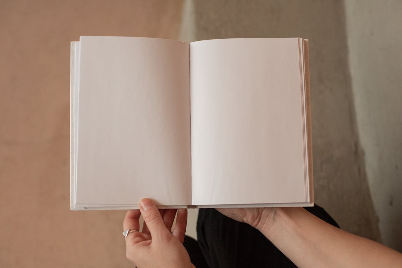 heros-img Hands holding an open blank notebook, perfect for concept or design projects with ample copy space.